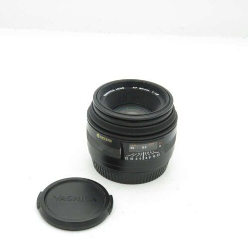 Camera lens marked "Yashica Lens AF 50mm 1:1.8" with a Yashica lens cap beside it.