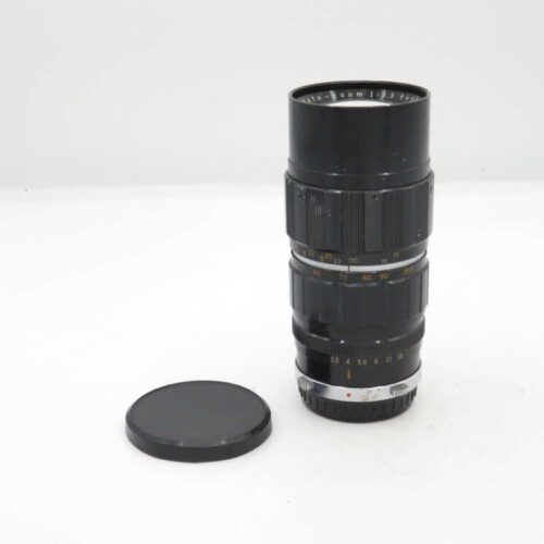 A black camera zoom lens with a detached lens cap on a white background.
