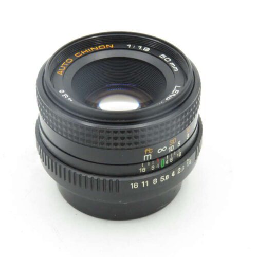 Close-up of an Auto Chinon 50mm f/1.9 camera lens on a white background.