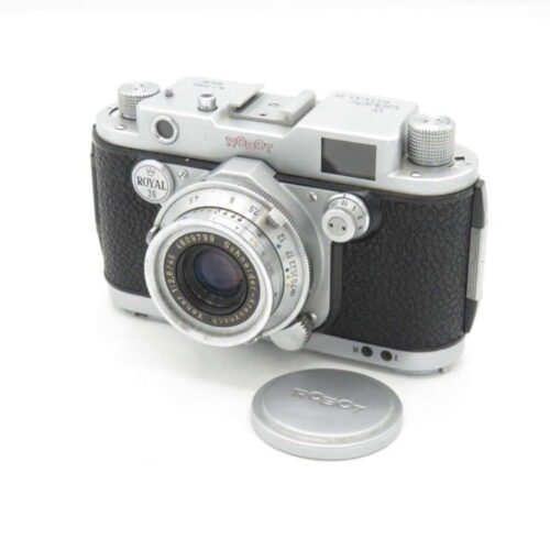 Vintage Robot Royal 36 camera with lens cap placed next to it.