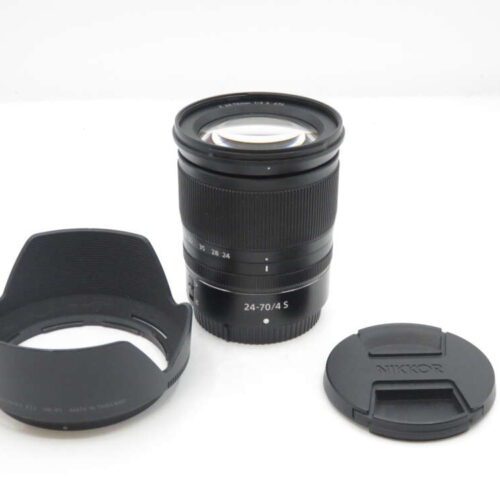 A black camera lens with a "24-70/4 S" label, placed between a lens hood and a lens cap.