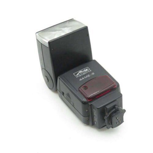 Black Metz mecablitz 44 MZ-2 external camera flash with white diffuser on white background.