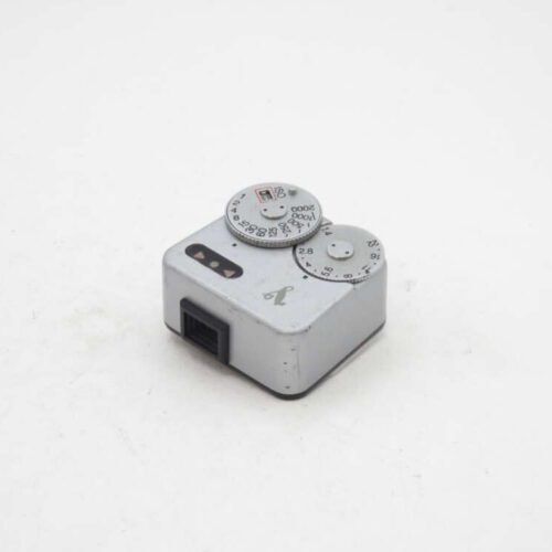 Close-up of a silver vintage light meter with dials on a white background.