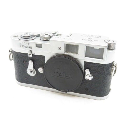 Vintage Leica film camera with black leatherette body and silver metal top, showing dials, viewfinder, and lens cap with "Leica" logo.