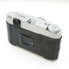 A vintage Fujifilm G617 panoramic film camera viewed from the back, showcasing its metallic top and black body with dials.