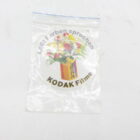 A transparent plastic bag containing an old Kodak label with a flower bouquet graphic and the text "laßt Farben sprechen" and "KODAK Filme".