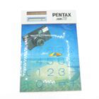 Pentax Zoom 70 calculator featuring a beach-themed design with a camera and an umbrella graphic.