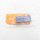 Sony memory stick in plastic packaging on an orange background.