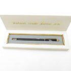 Black pentax fashion ball point pen in an open white gift box with gold trim.