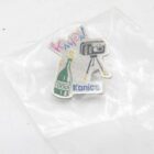 Konica pin with illustrations of a green champagne bottle and a black camera on a tripod, in a plastic bag.