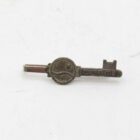 A small vintage key with the inscription "PETRI" and intricate designs on the end.