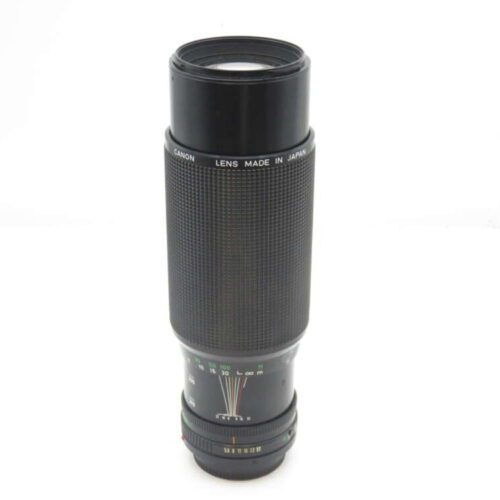 Canon camera lens with textured grip, made in Japan, against a plain white background.