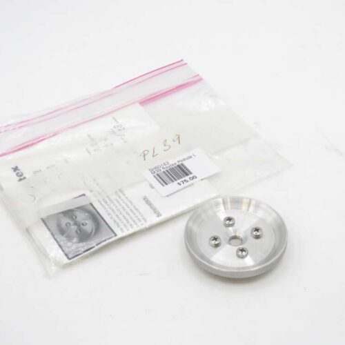 Metallic round part with five small screws, next to a plastic bag containing papers and a label with text including a price of $75.00.