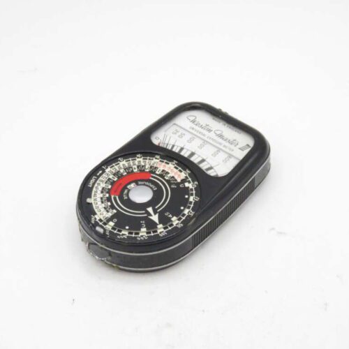 Black handheld vintage light meter with a circular dial and a rectangular display labeled "Weston Master III Universal Exposure Meter" on a white background.