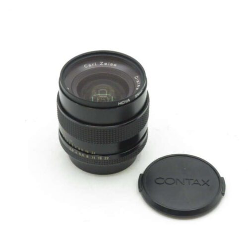 Camera lens with "Carl Zeiss" and "Hoya" markings next to a black lens cap with "Contax" written on it.