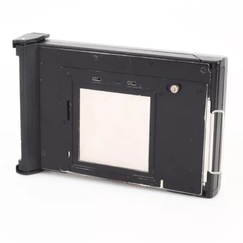Black rectangular film holder for large format cameras with a central white rectangle, metal clip on the side and plastic frame.