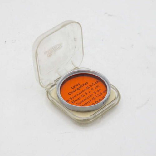 Orange Leica camera filter in a clear plastic case.
