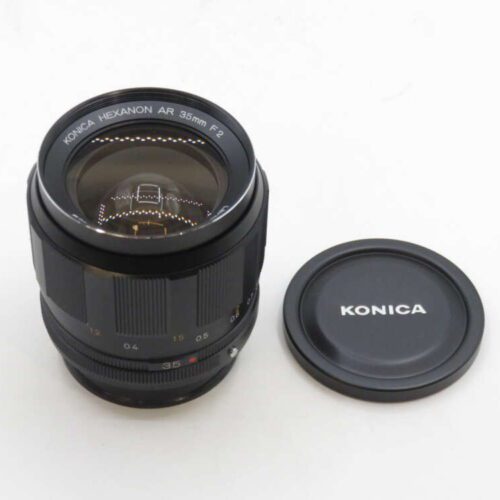 Konica Hexanon AR 35mm F2 camera lens with lens cap beside it.