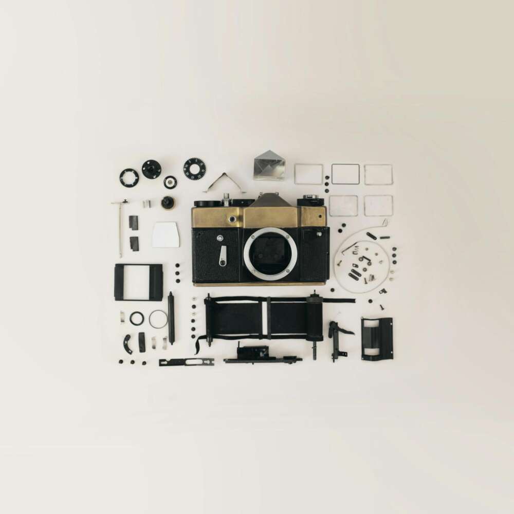 Disassembled vintage camera parts arranged on a flat surface.