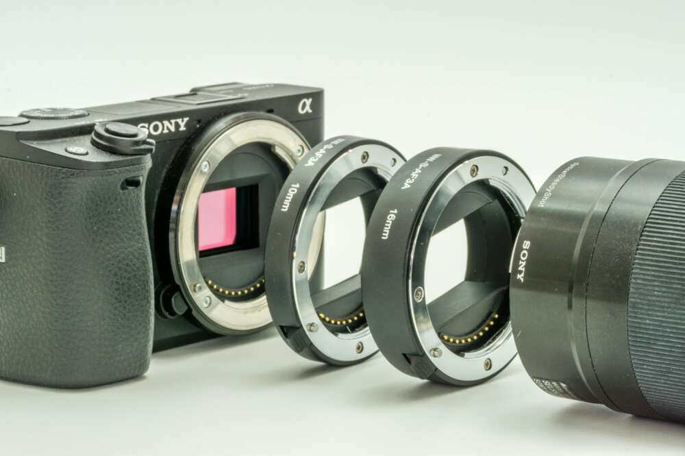 Sony camera with lens mount adapters and a lens arranged in a row.