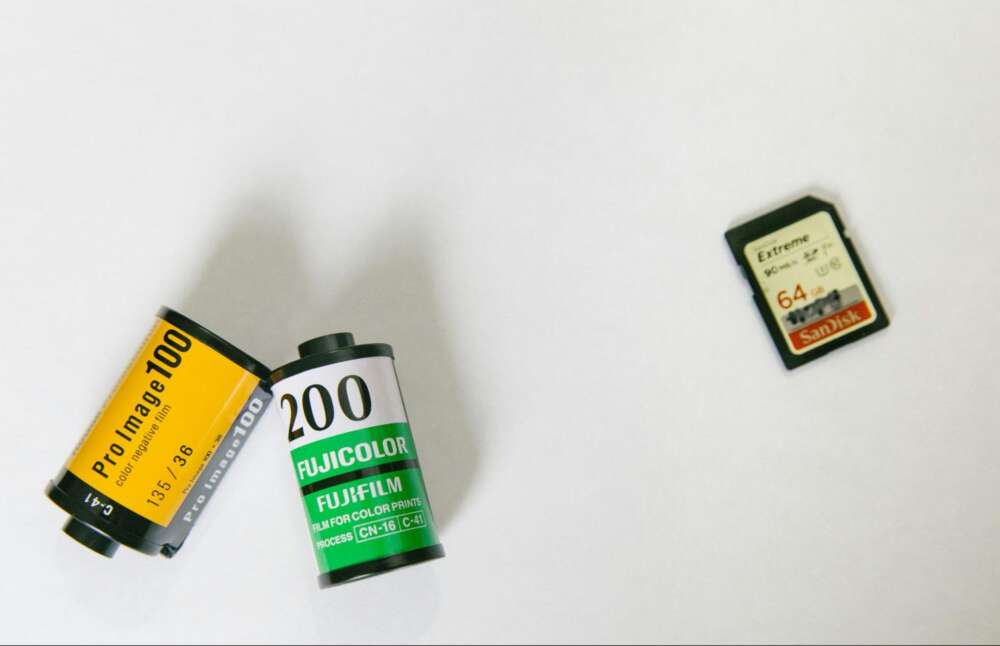 Two rolls of film and a SanDisk SD card on a white surface.