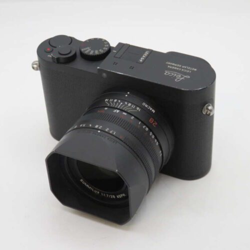 A black Leica Q digital camera with a lens hood attached.