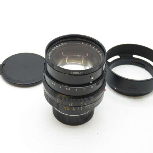 Camera lens with a lens cap and hood on a white background.