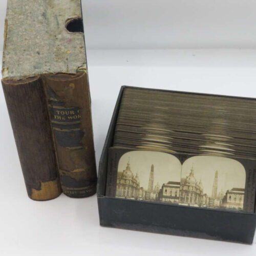 Two vintage books titled "Tour of the World" next to a box of stereoscopic cards featuring architectural images.