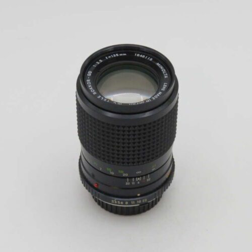 A vintage Minolta lens with "MD TELE ROKKOR-QD" and "f=135mm" markings on a white background.