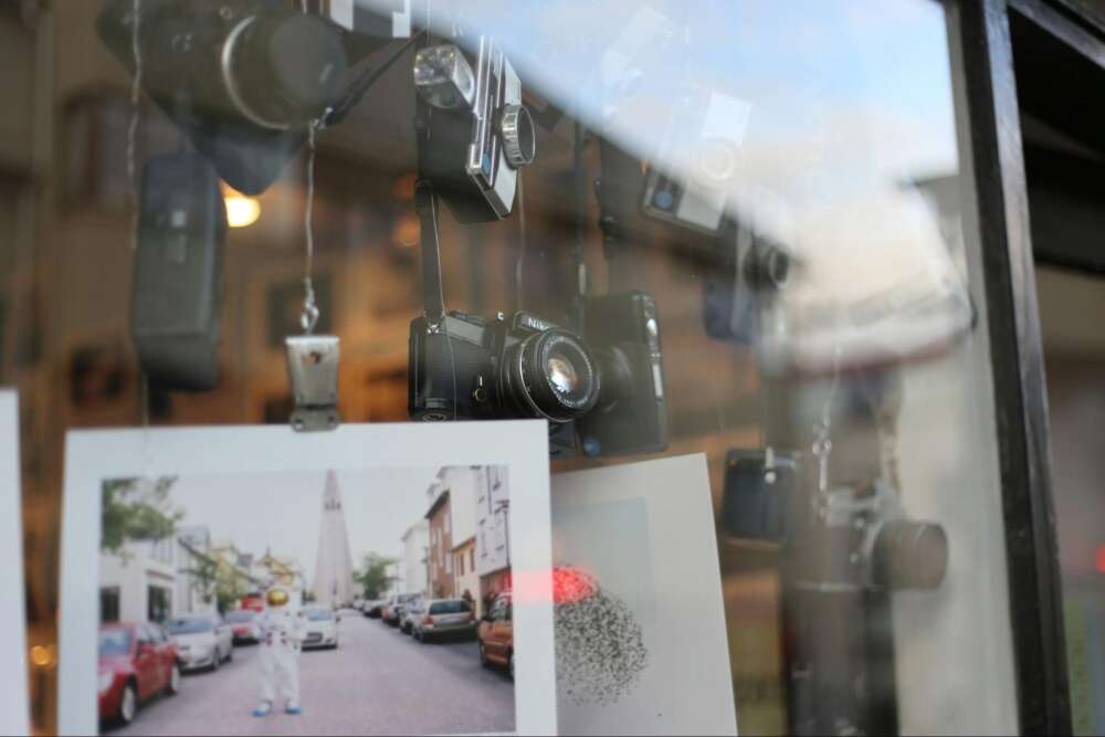 Vintage cameras and photographs displayed in a shop window.