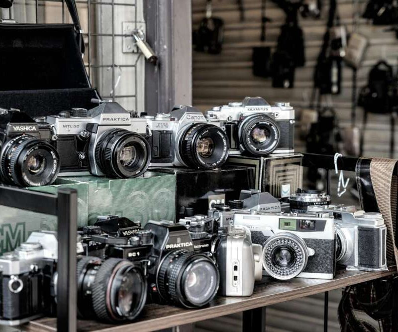 A collection of vintage cameras displayed on shelves.