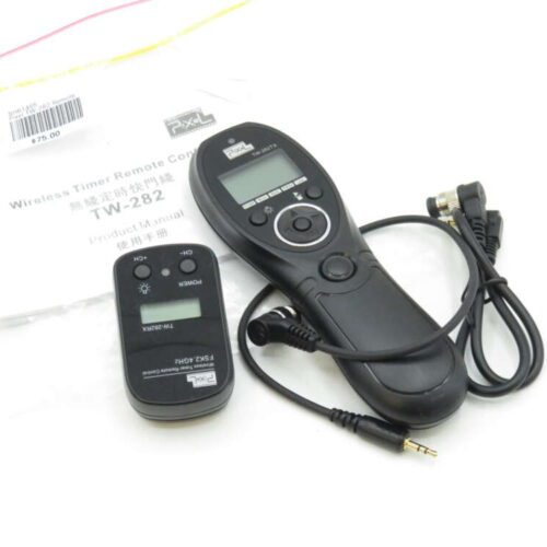 Black wireless timer remote control set, including two devices and a cable, with an instruction manual partially visible in the background.