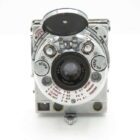 Le Coultre Compass Camera with a circular lens and various dials and settings, featuring a metallic finish.