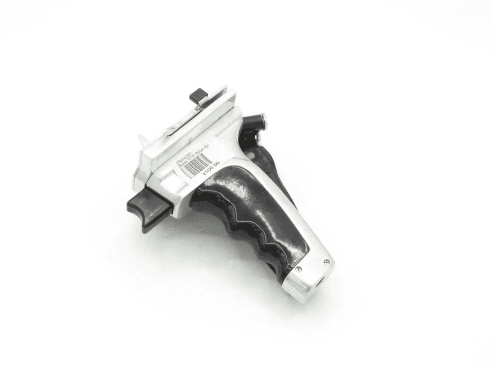A silver and black toy gun with a barcode sticker on the side, viewed from above on a white background.
