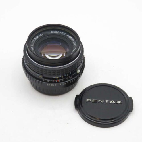 An Asahi Pentax 50mm f/1.7 camera lens with a detached Pentax lens cap on a white background.