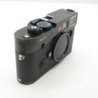 Alt text: Black Leica M7 film camera with a textured grip and a lens cap attached.