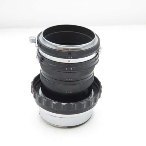 A black and silver vintage camera lens with multiple focus rings and adjustment knobs.