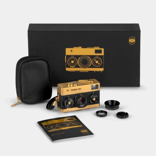 A gold and black Rollei 35 camera set, with a black case, lens accessories, and a booklet labeled 'Gold Edition', presented in front of a black box with a gold camera illustration.
