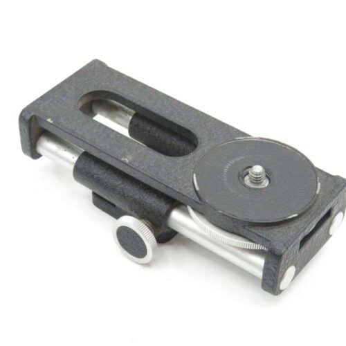 A black camera quick release plate with a silver screw mount and adjustment knob, designed for attaching a camera to a tripod.