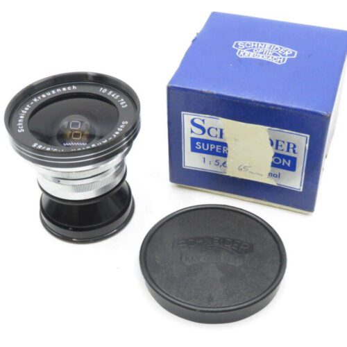 A Schneider-Kreuznach Super-Angulon camera lens with lens cap, placed next to its original blue box.
