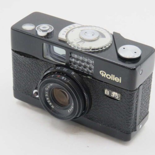 A vintage Rollei B 35 film camera with a black textured body, featuring a lens marked 'Made by Rollei', and a silver dials on top for settings.