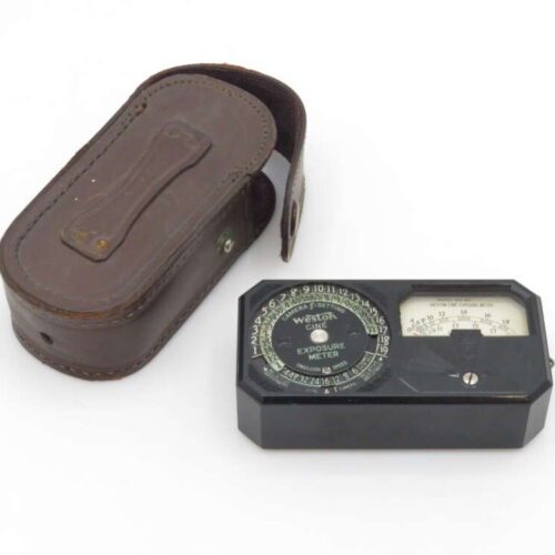 A vintage Weston Cine Exposure Meter with a black exterior and circular dials, accompanied by a brown leather carrying case on a white background.