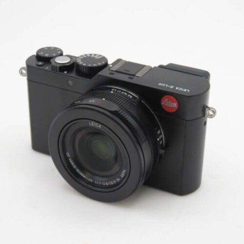 A black Leica D-Lux camera with a large lens, various control dials, and the Leica logo displayed on the top right corner, set against a plain white background.