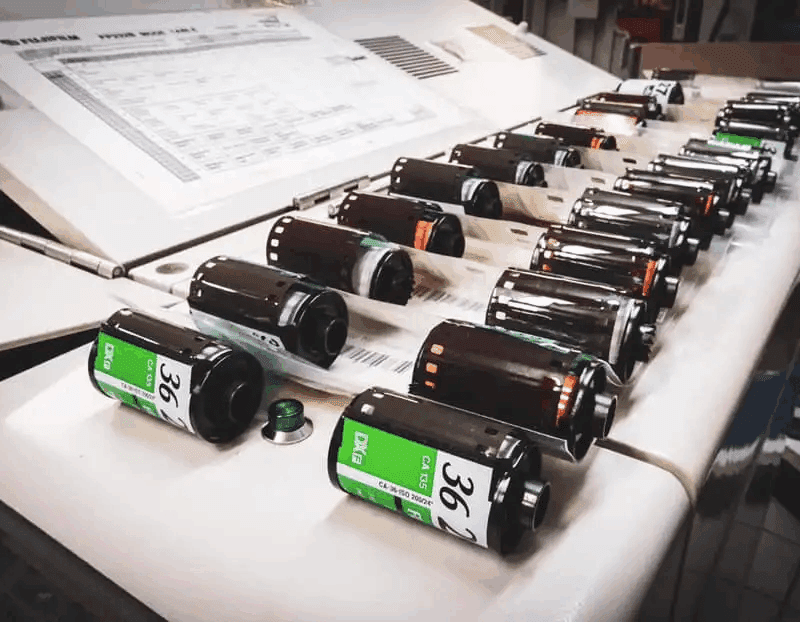 Multiple rolls of undeveloped film sit on a flat surface for film developing Adelaide