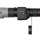 Side view of a Kite Optics grey and black telescope with a lens cover attached by a strap.