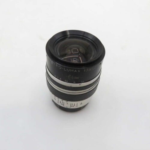 A vintage Petri Orikkor 1:3.5 f=6cm camera lens with a black and silver barrel, featuring distance markings and an aperture scale on its side, standing upright against a plain white background.