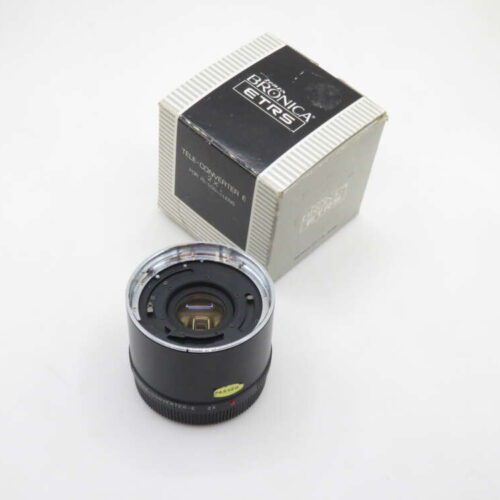 A Bronic ETRS tele-converter lens positioned next to its original packaging on a plain background.