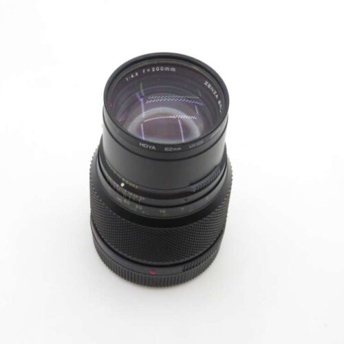 A black camera lens labeled "HOYA 52mm 1:4.5 f=200mm," with a wide focusing ring and visible lens coating reflections, set against a plain white background.