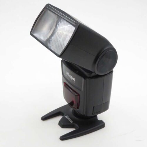 A Nissin camera flash with a large rectangular head mounted on a small black stand, positioned against a plain white background.