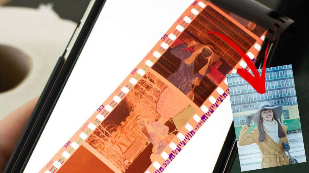 A film negative is placed over the screen of a smartphone,for film scanning Adelaide